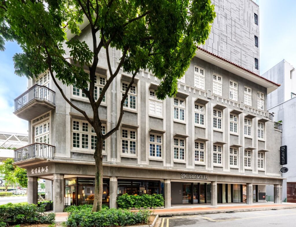 e4794959-fdc3-4edb-98a5-6c19d5c45649 exterior of 21 Carpenter heritage hotel in Singapore with Chinese calligraphy and upper aluminium design