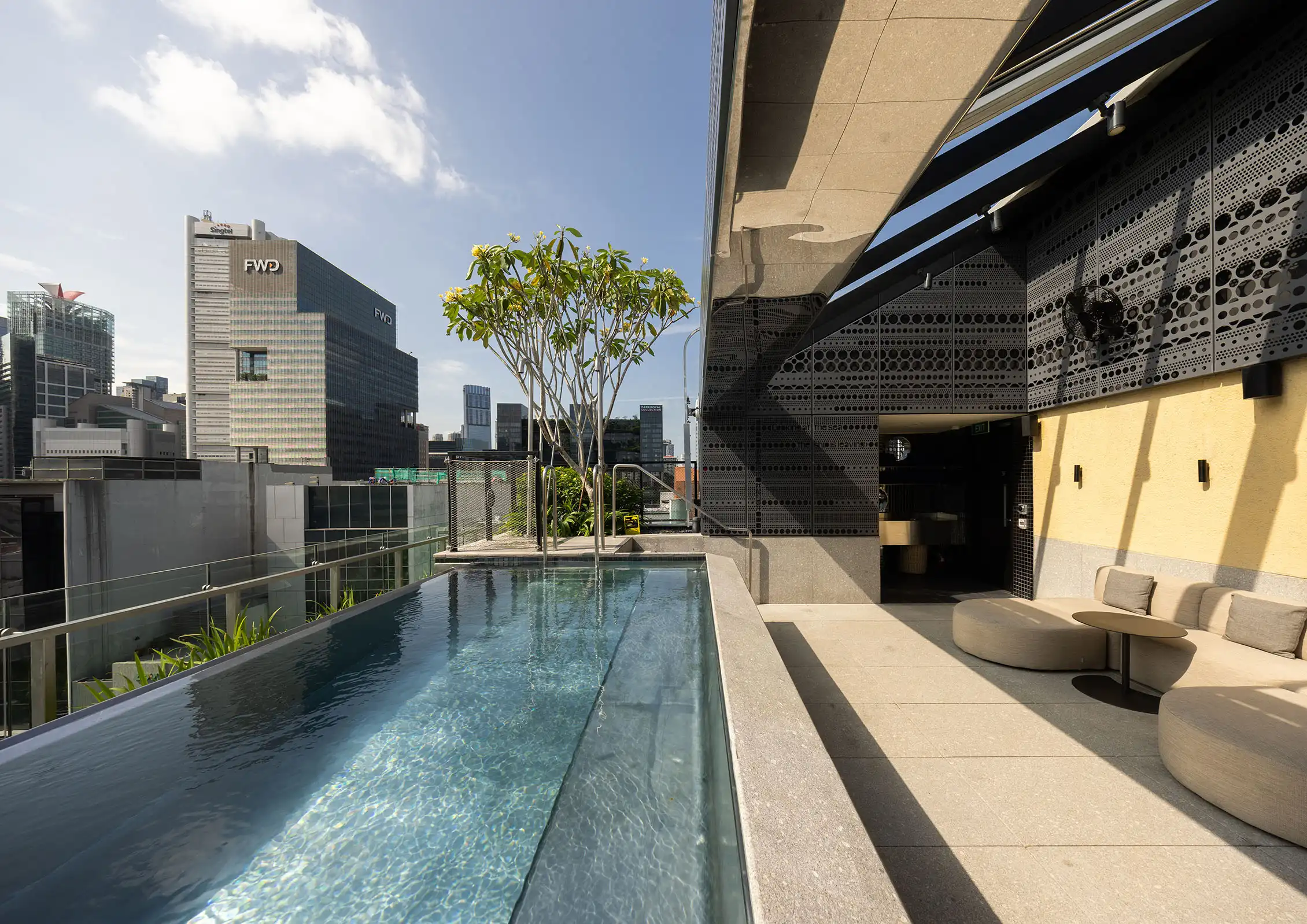 Rooftop infinity pool at 21 Carpenter Singapore with city skyline views and lounge seating.